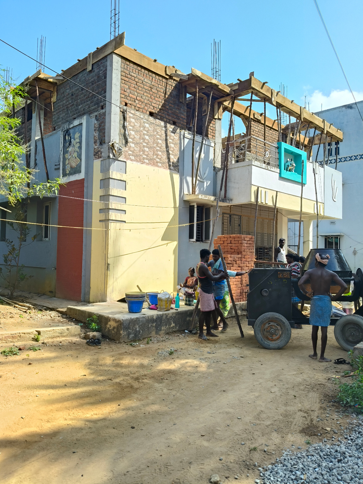 Second floor addition renovation project with workers on scaffolding in Kumbakonam